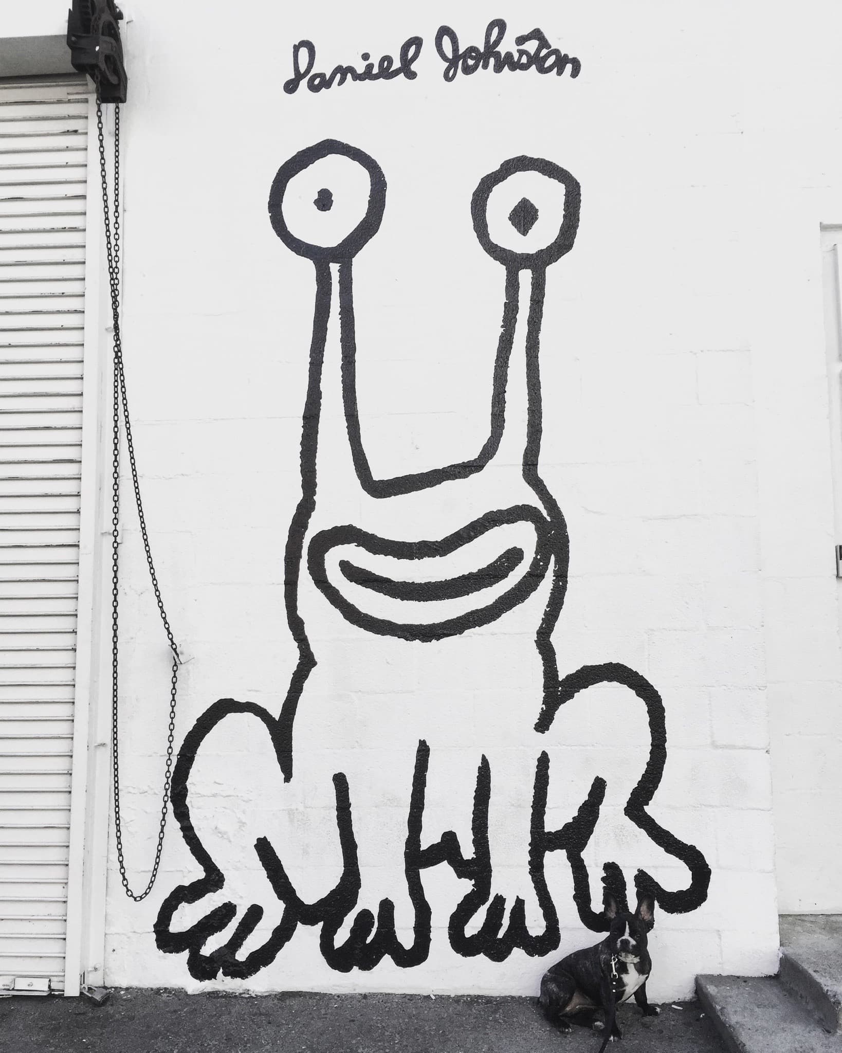 Maddie standing in front of street art in Needs location, Location unknown